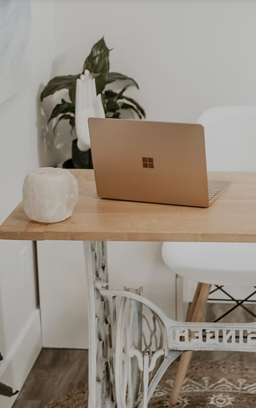 Salt lamp and laptop on a wooden desk in the Rituale Olistica & Spa studio